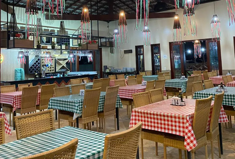 Restaurante e Pizzaria na Pousada Bellíssima Itália, Luis Correia Salão interno do Restaurante e Pizzaria da Pousada Bellíssima Itália em Luis Correia, com mesas postas.