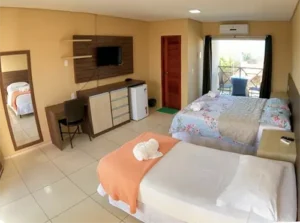 Quarto triplo confortável para família na Pousada Bellíssima Itália, Luis Correia, com cama de casal, cama de solteiro e varanda.
